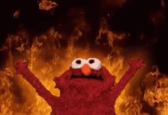 Elmo in flames, raising his arms in triumph.